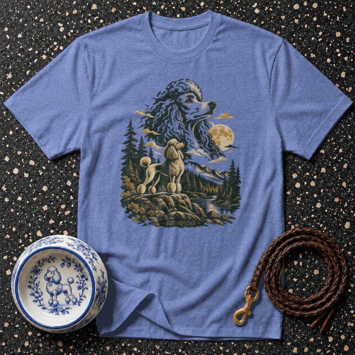 Blue t-shirt featuring a graphic of two poodles in a forest landscape at night.