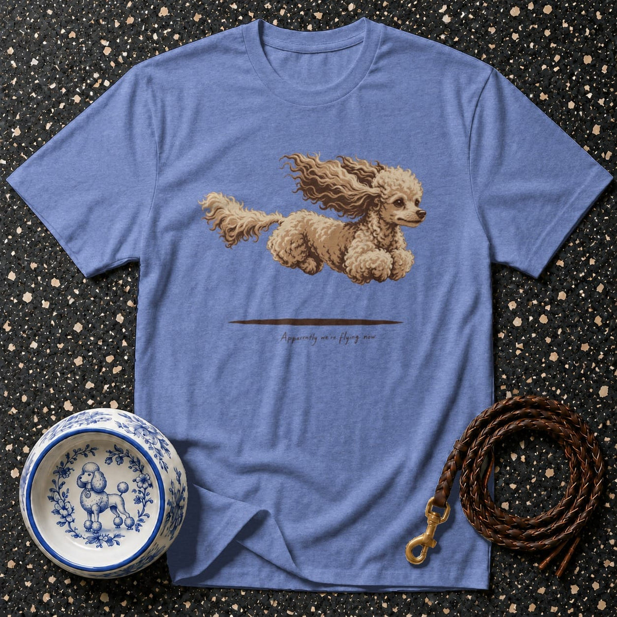 Blue t-shirt with a flying poodle graphic and text "Apparently we're flying now."