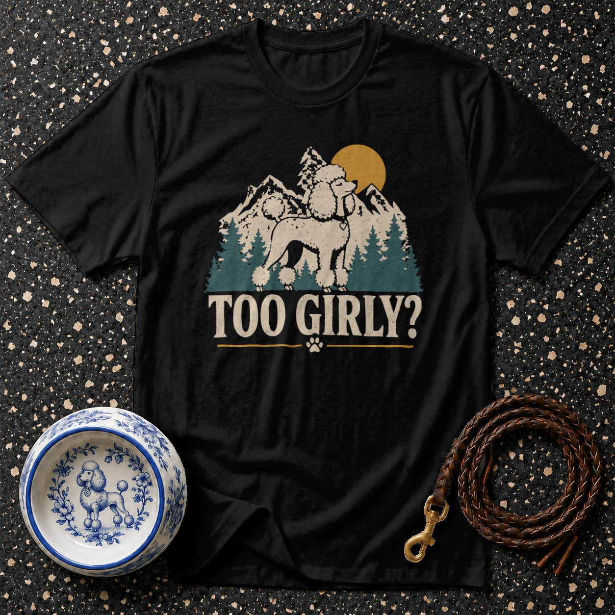Black t-shirt with a poodle silhouette, mountains, trees, sun, and text "TOO GIRLY?".