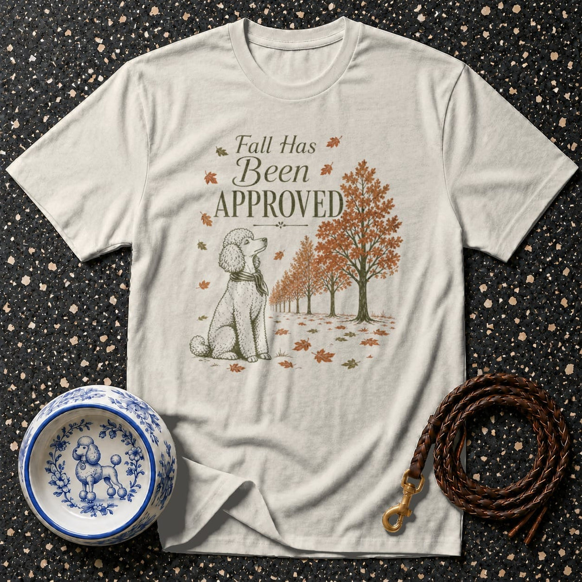 Light t-shirt with a poodle and autumn trees graphic that says "Fall Has Been Approved".