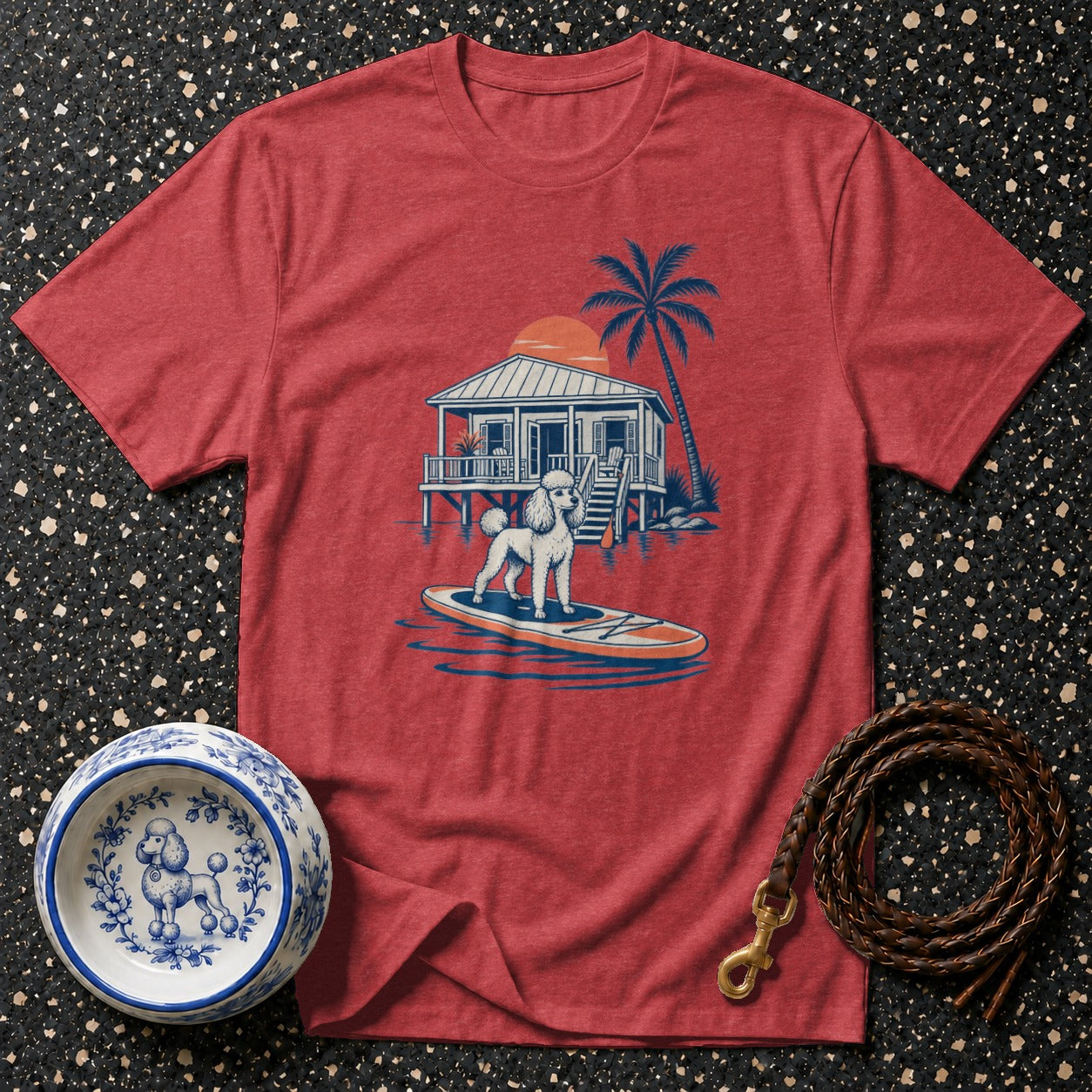 Red t-shirt with poodle on paddleboard and beach house graphic.
