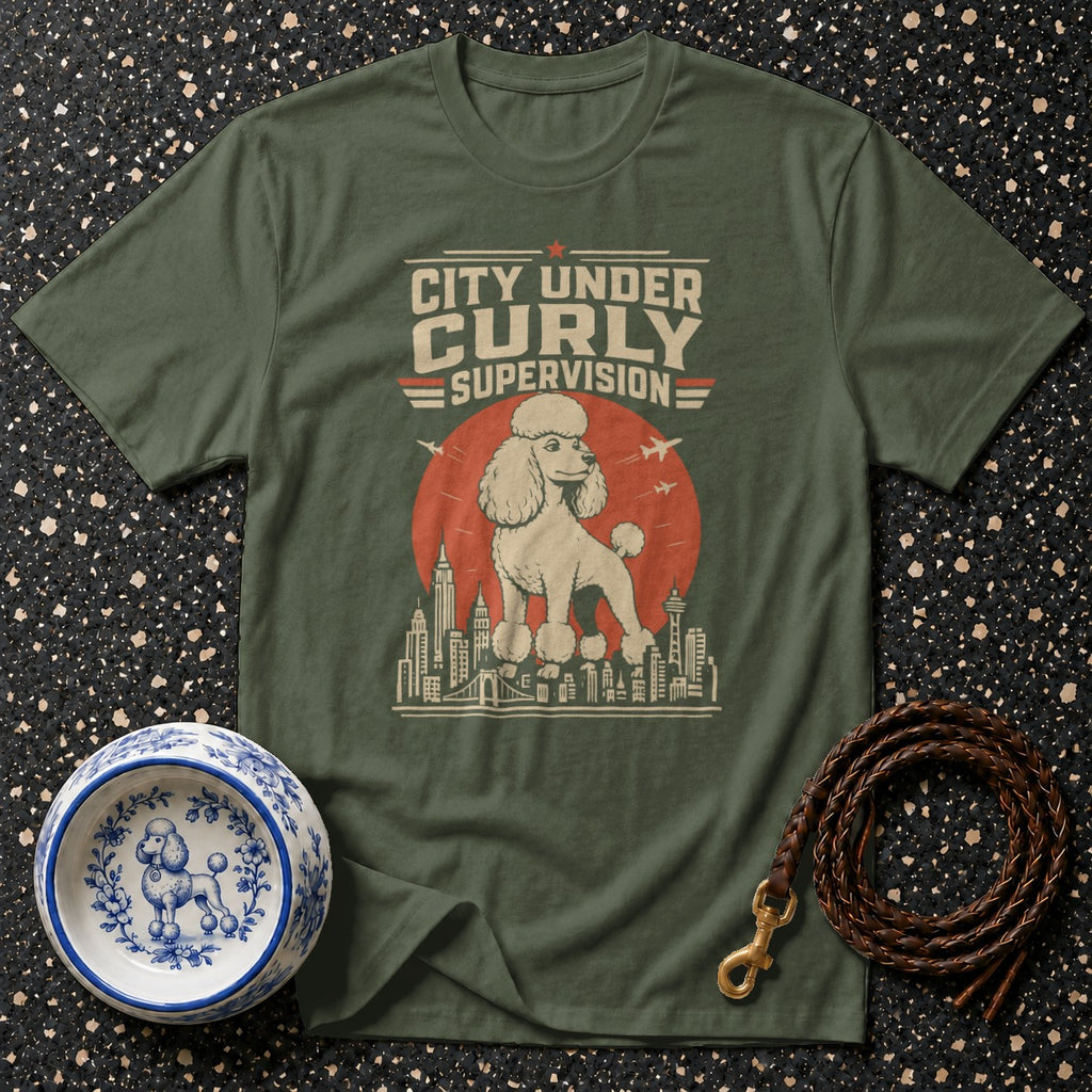 Olive t-shirt with "City Under Curly Supervision" text and poodle graphic.