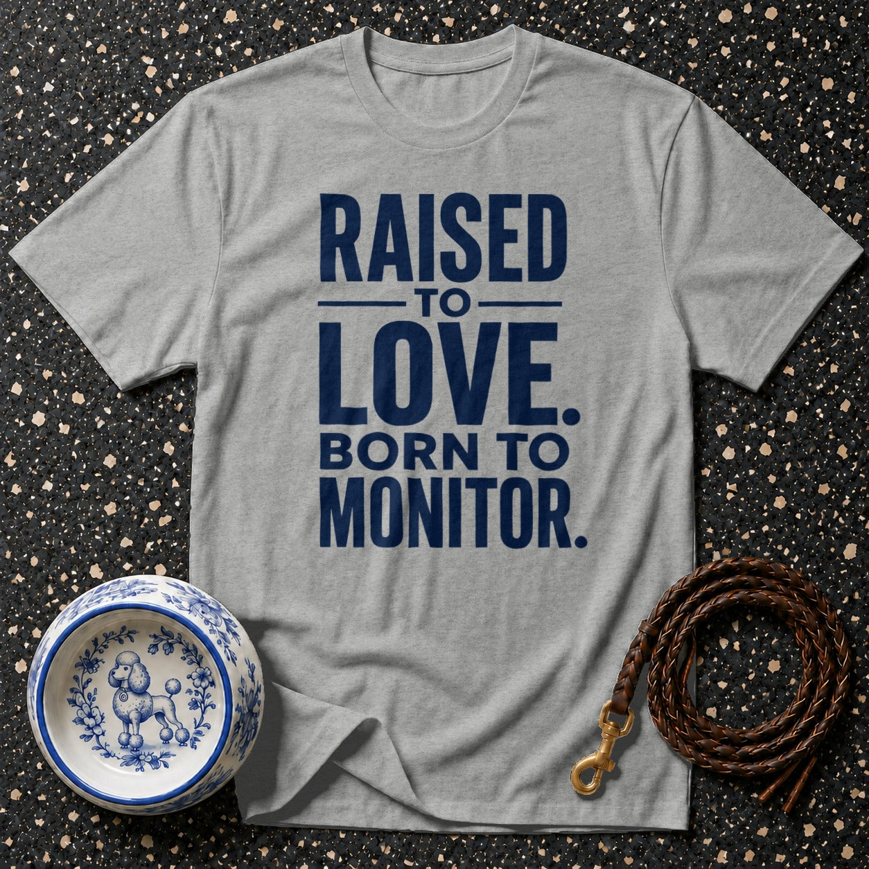 Grey t-shirt with "RAISED TO LOVE. BORN TO MONITOR." text.