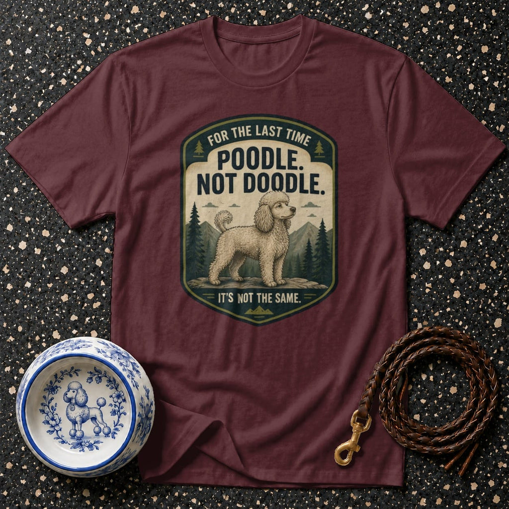 Maroon t-shirt with a graphic of a poodle in a forest setting, saying "Poodle. Not Doodle."