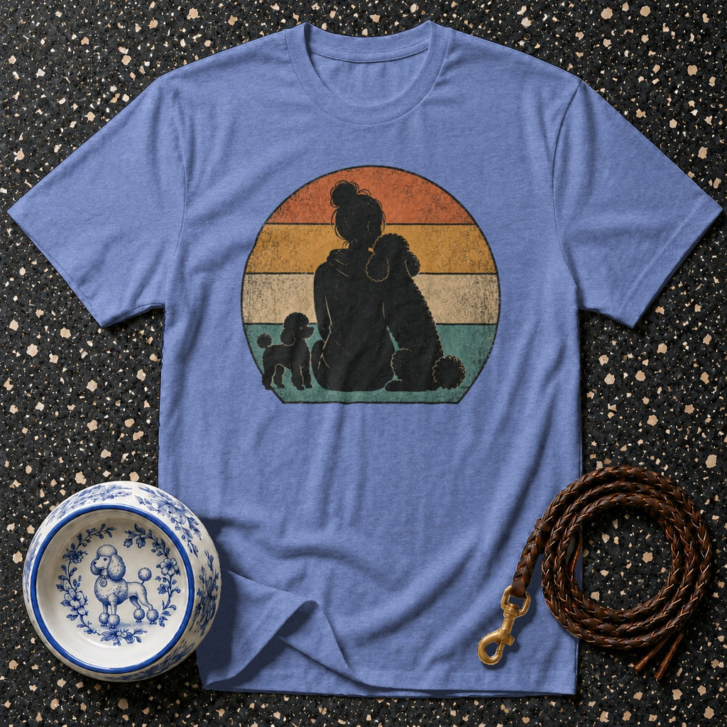 T-shirt with a black silhouette of a person and two poodles against a sunset circle graphic.