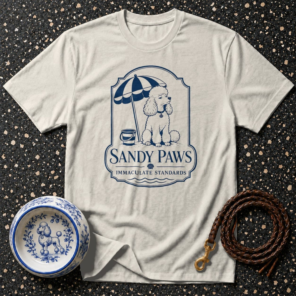 Cream t-shirt with Sandy Paws logo featuring a poodle under an umbrella on the beach.
