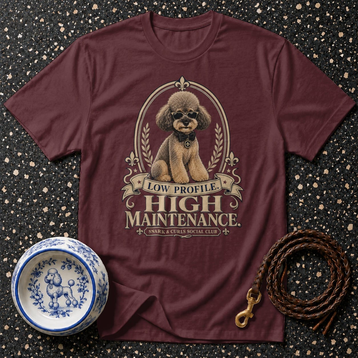 Maroon t-shirt with poodle graphic and text: Low Profile. High Maintenance. Snark & Curls Social Club.