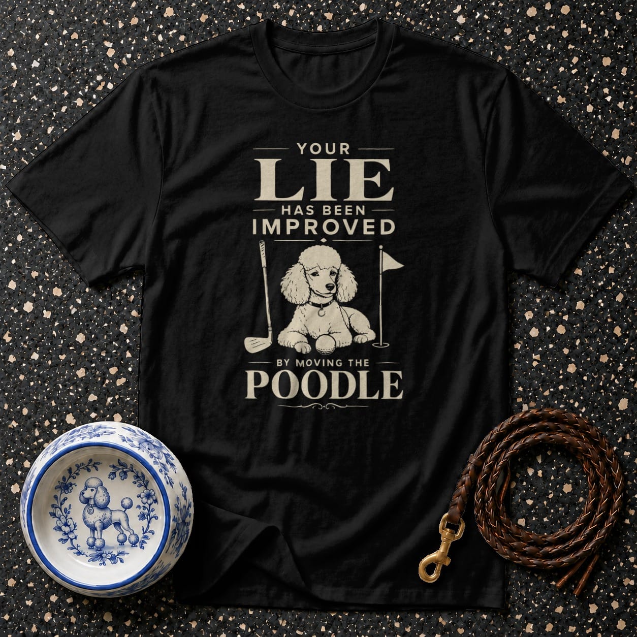 Black t-shirt with text "YOUR LIE HAS BEEN IMPROVED BY MOVING THE POODLE" and poodle graphic.
