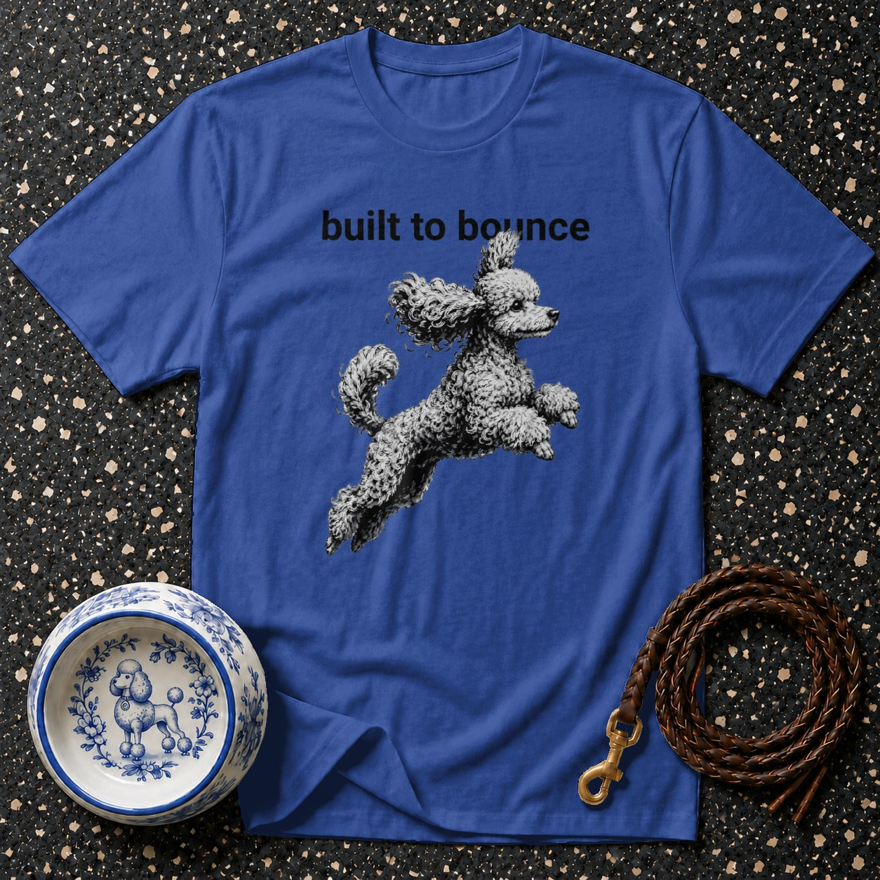 Blue t-shirt with "built to bounce" text and a leaping poodle graphic.
