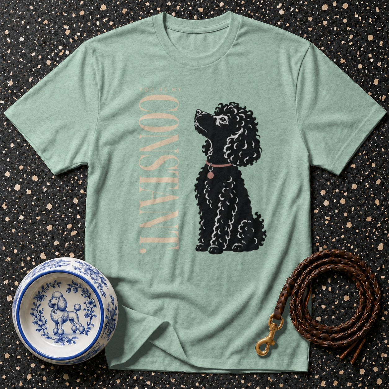 Light green t-shirt with black poodle illustration and "CONSTANT" text.