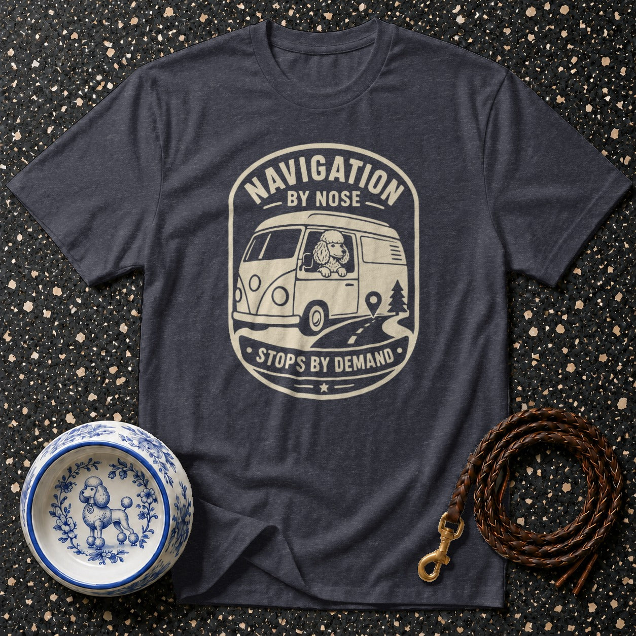 Dark grey t-shirt with graphic of a poodle in a van, text "Navigation by Nose Stops by Demand."
