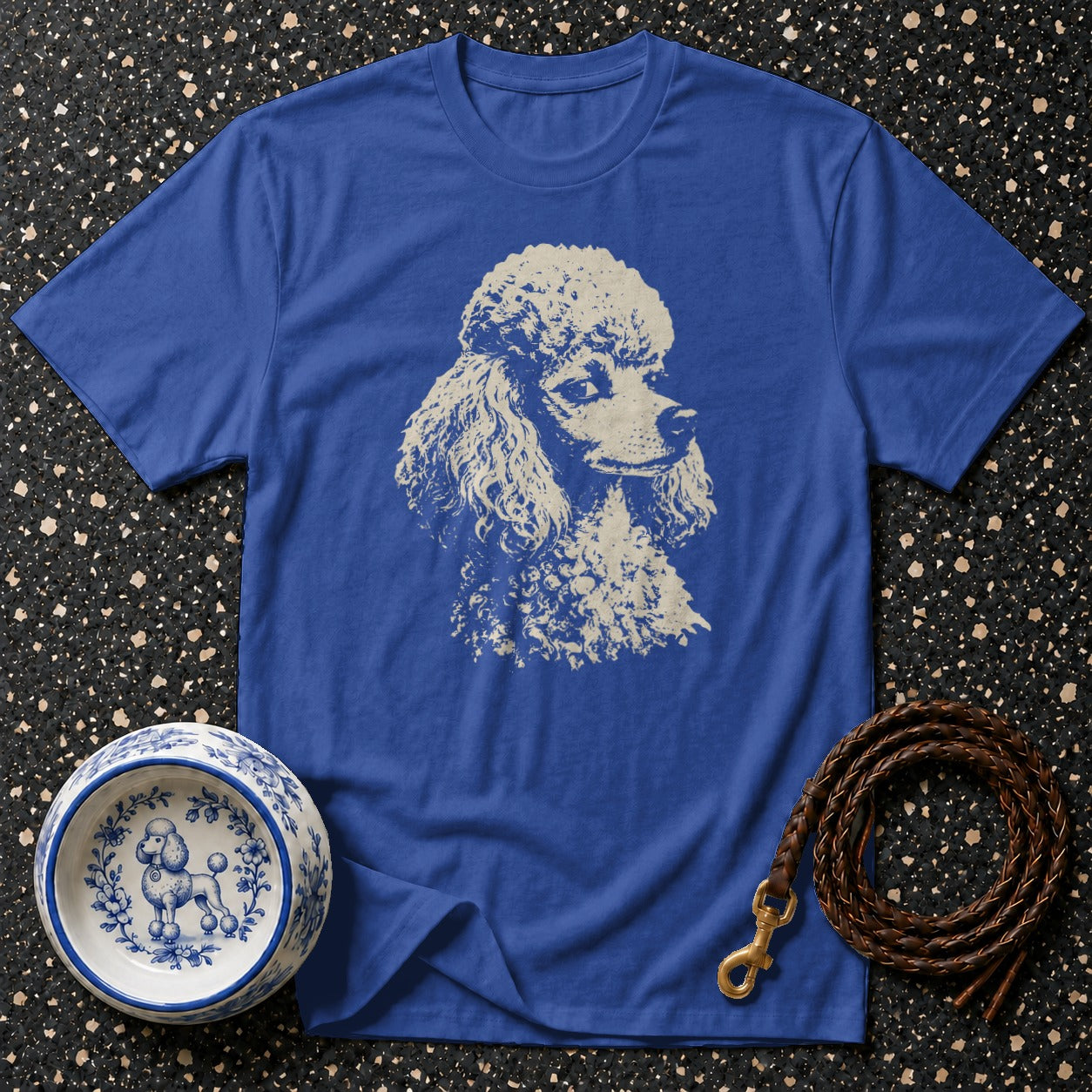 Blue t-shirt with vintage poodle graphic, decorative dog bowl, and leather leash.