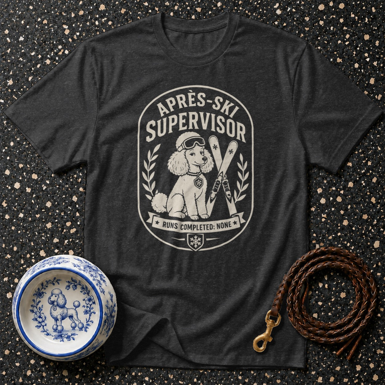 Dark grey t-shirt with "Aprés-Ski Supervisor" graphic of a poodle and skis.