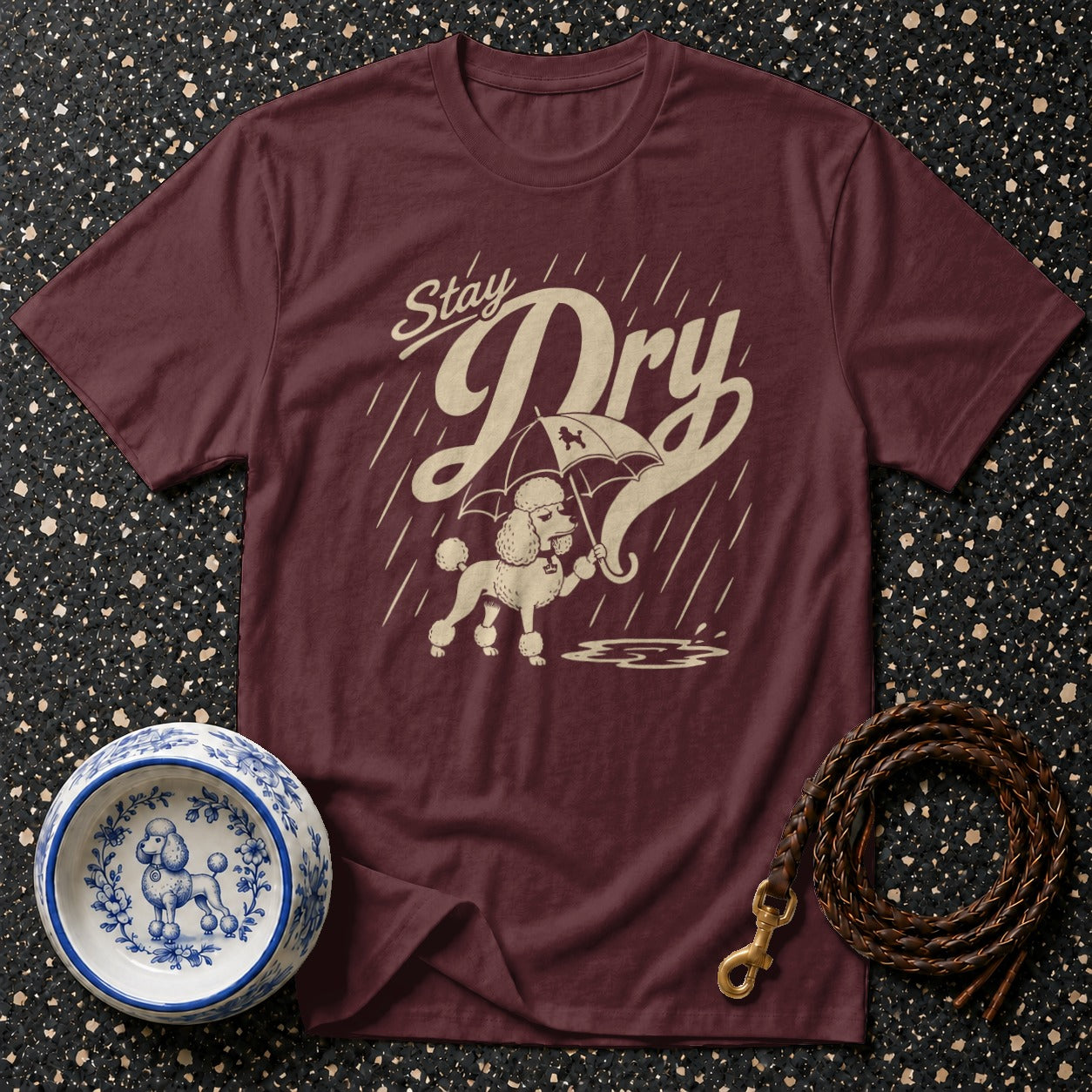 Maroon t-shirt with a poodle holding an umbrella under "Stay Dry" text.