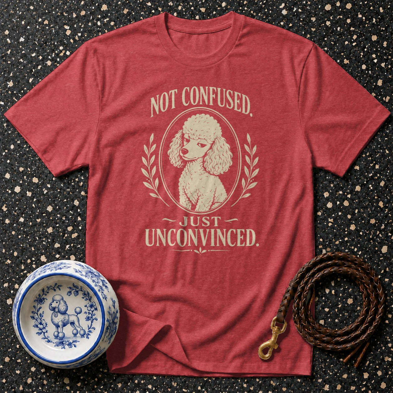 Red t-shirt with cream graphic of a poodle and text "NOT CONFUSED. JUST UNCONVINCED."
