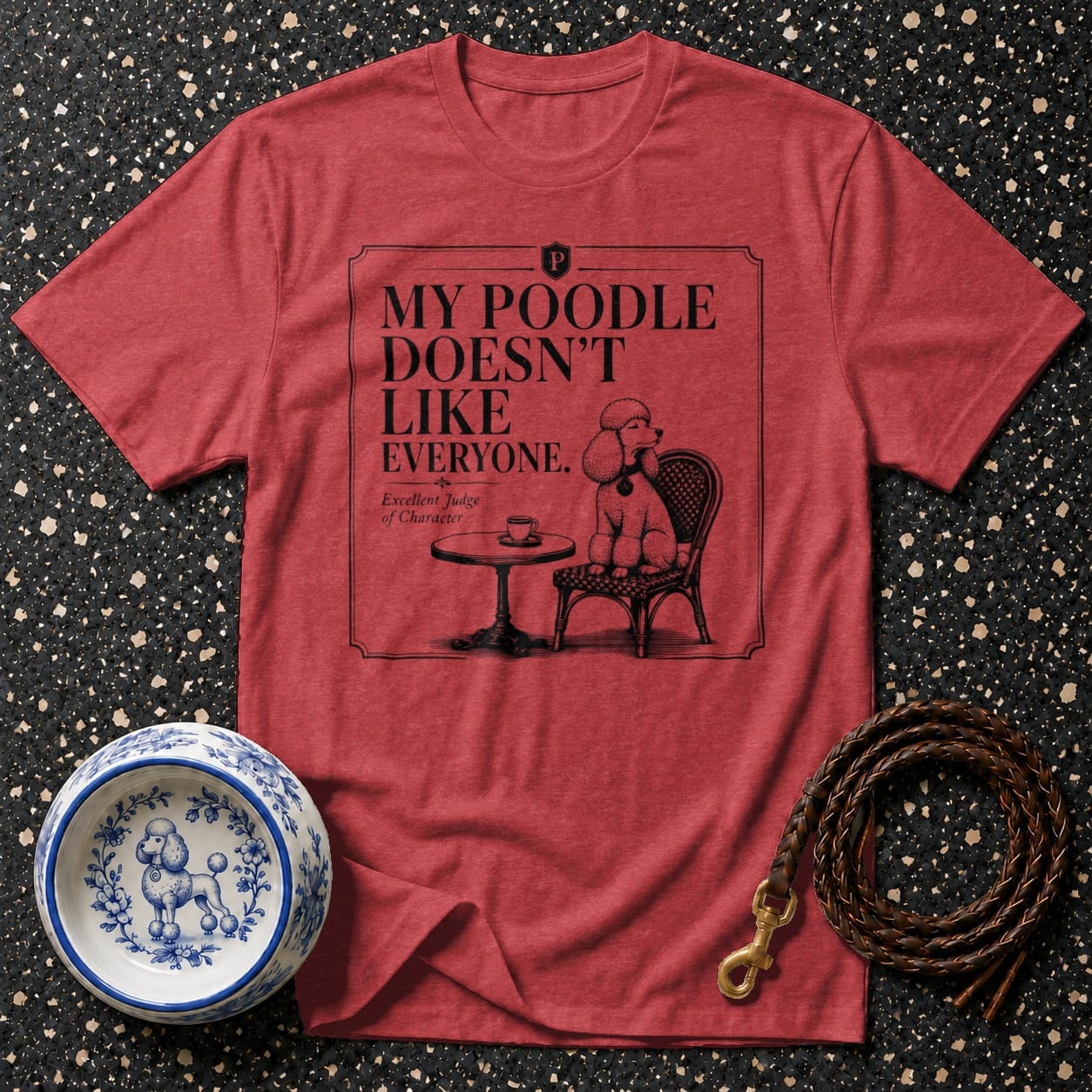 Red t-shirt with illustration of a poodle on a chair with text "My poodle doesn't like everyone".