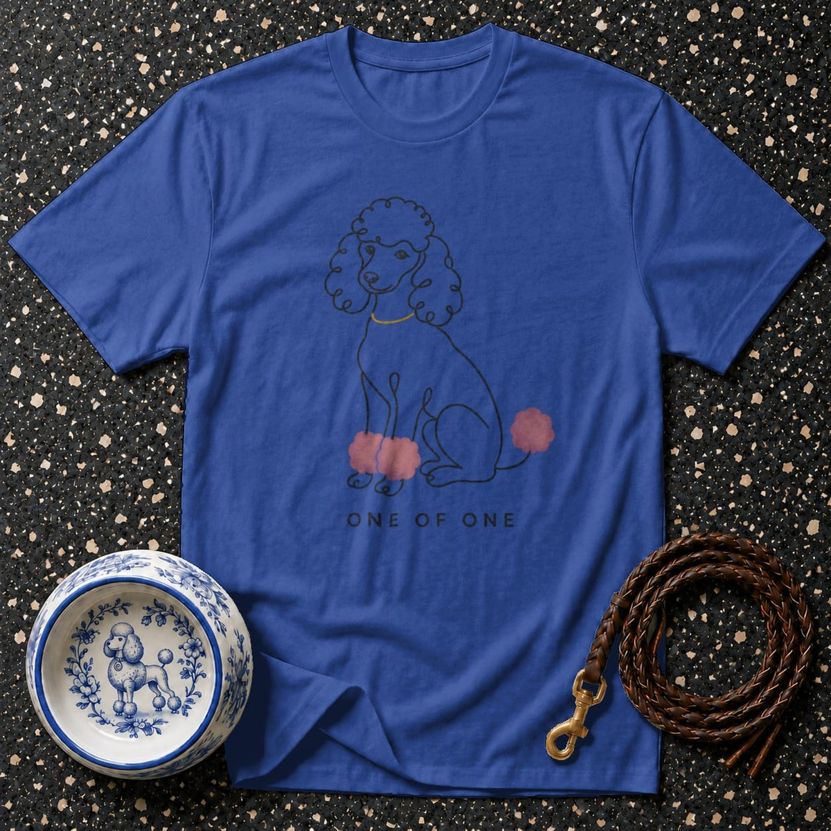Blue t-shirt with a line drawing of a poodle and text "ONE OF ONE".