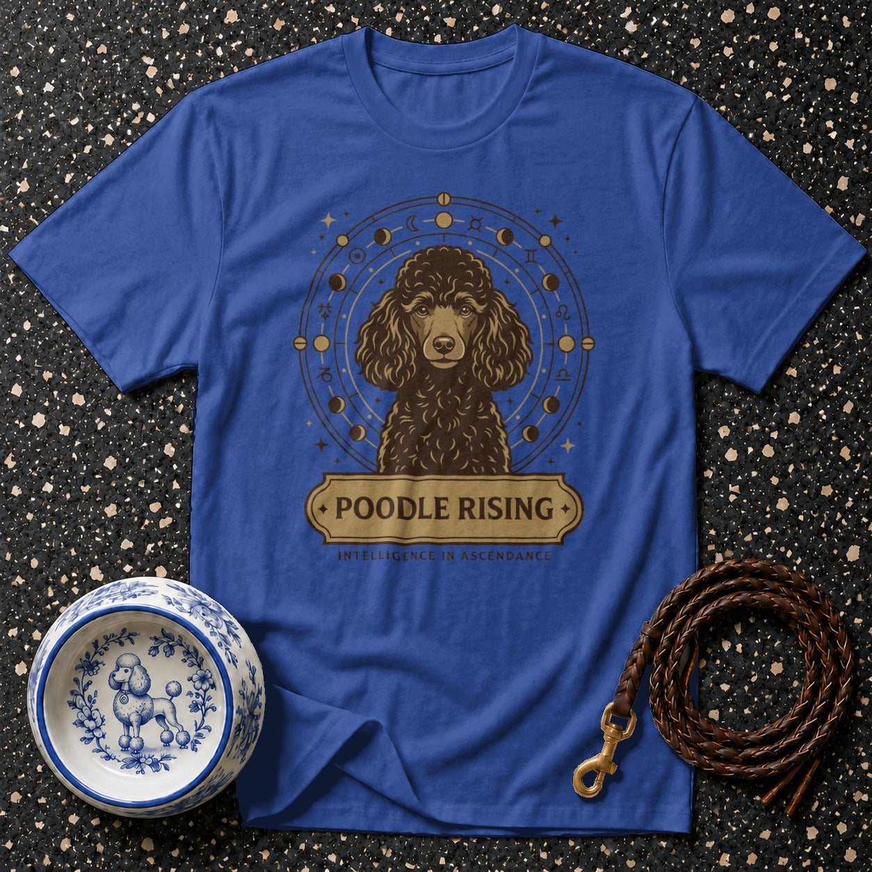 Blue t-shirt with a poodle graphic and astrological symbols. Text reads "Poodle Rising".