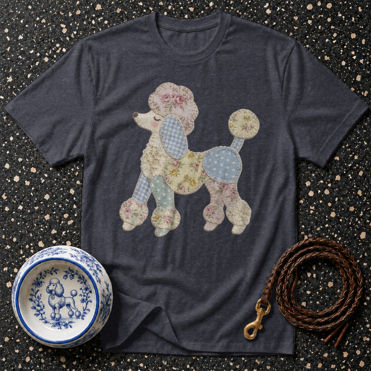 Dark grey t-shirt with a patchwork poodle graphic, a blue and white patterned dog bowl, and a leather leash.