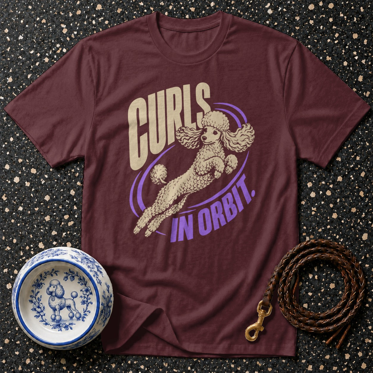 Burgundy t-shirt with a poodle in orbit graphic and "Curls in Orbit" text.