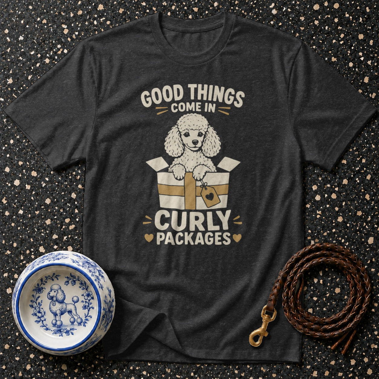 Dark t-shirt with poodle in a box graphic and text "Good things come in curly packages".