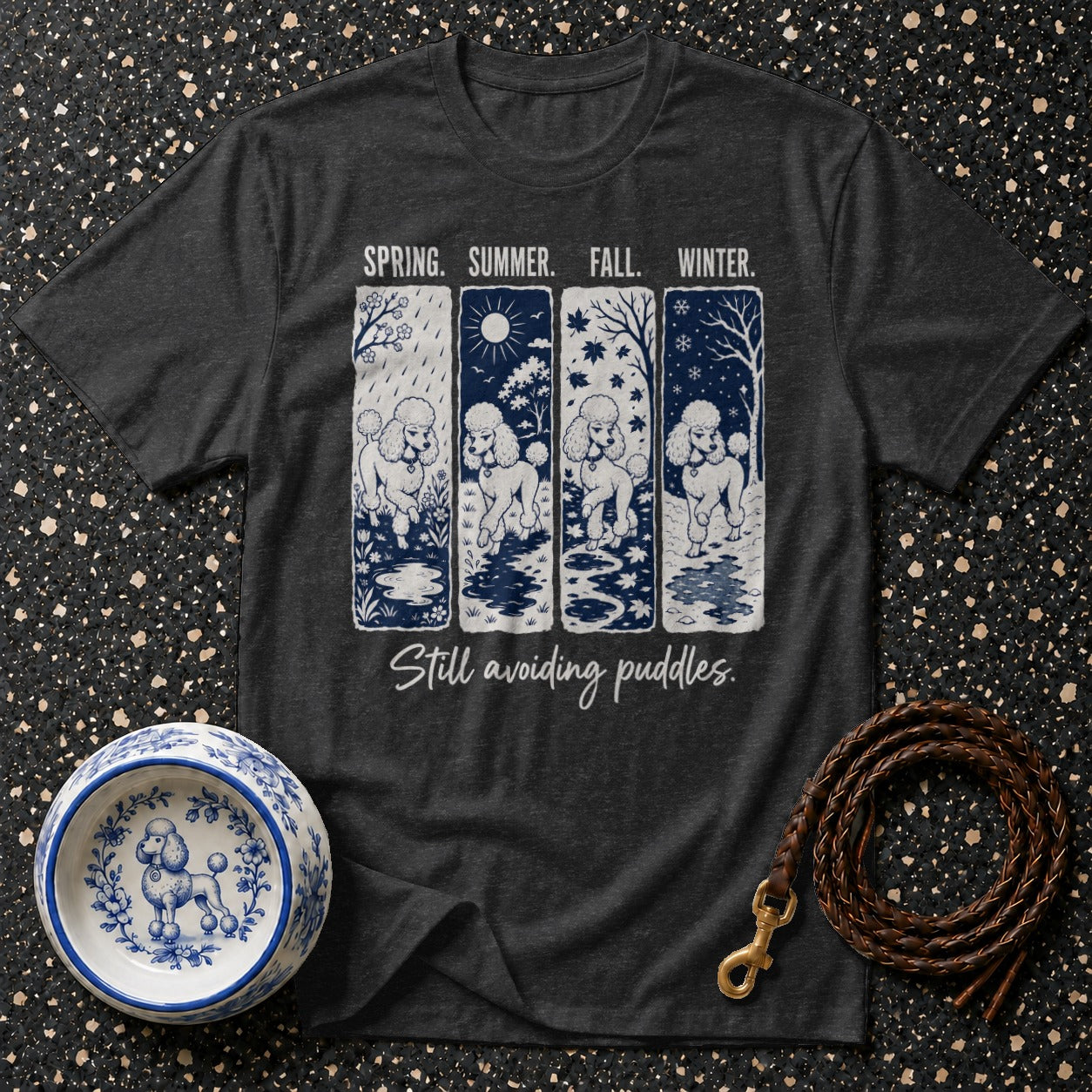 Dark t-shirt with poodles in spring, summer, fall, and winter scenes; "Still avoiding puddles."