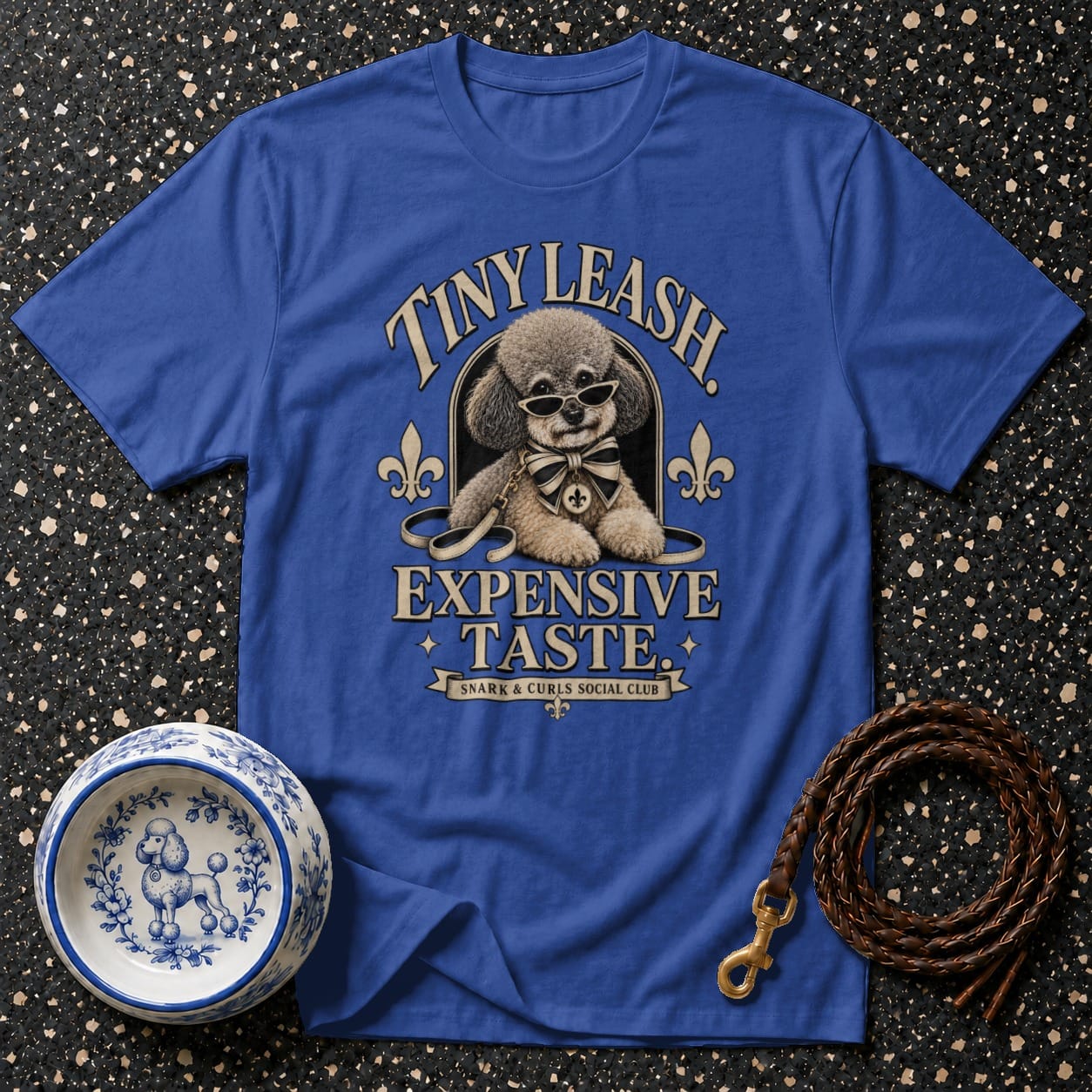 Blue t-shirt with a poodle wearing sunglasses and a bow tie. Text reads "Tiny Leash Expensive Taste".