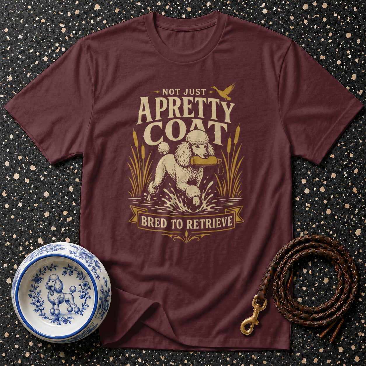 Maroon t-shirt with a poodle retrieving in water, "Not Just A Pretty Coat" text.