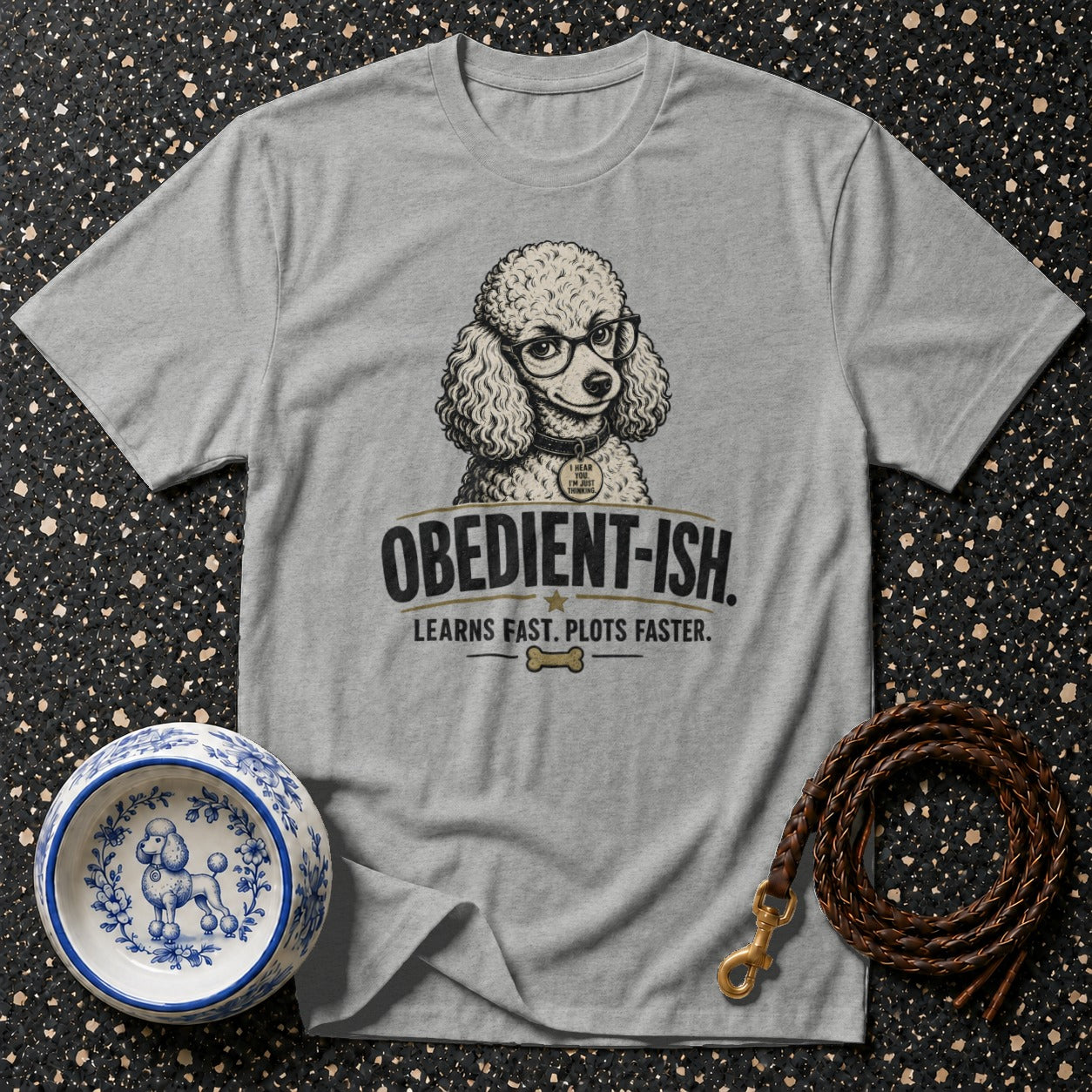 Grey t-shirt with poodle graphic and "Obedient-ish. Learns fast. Plots faster." text.
