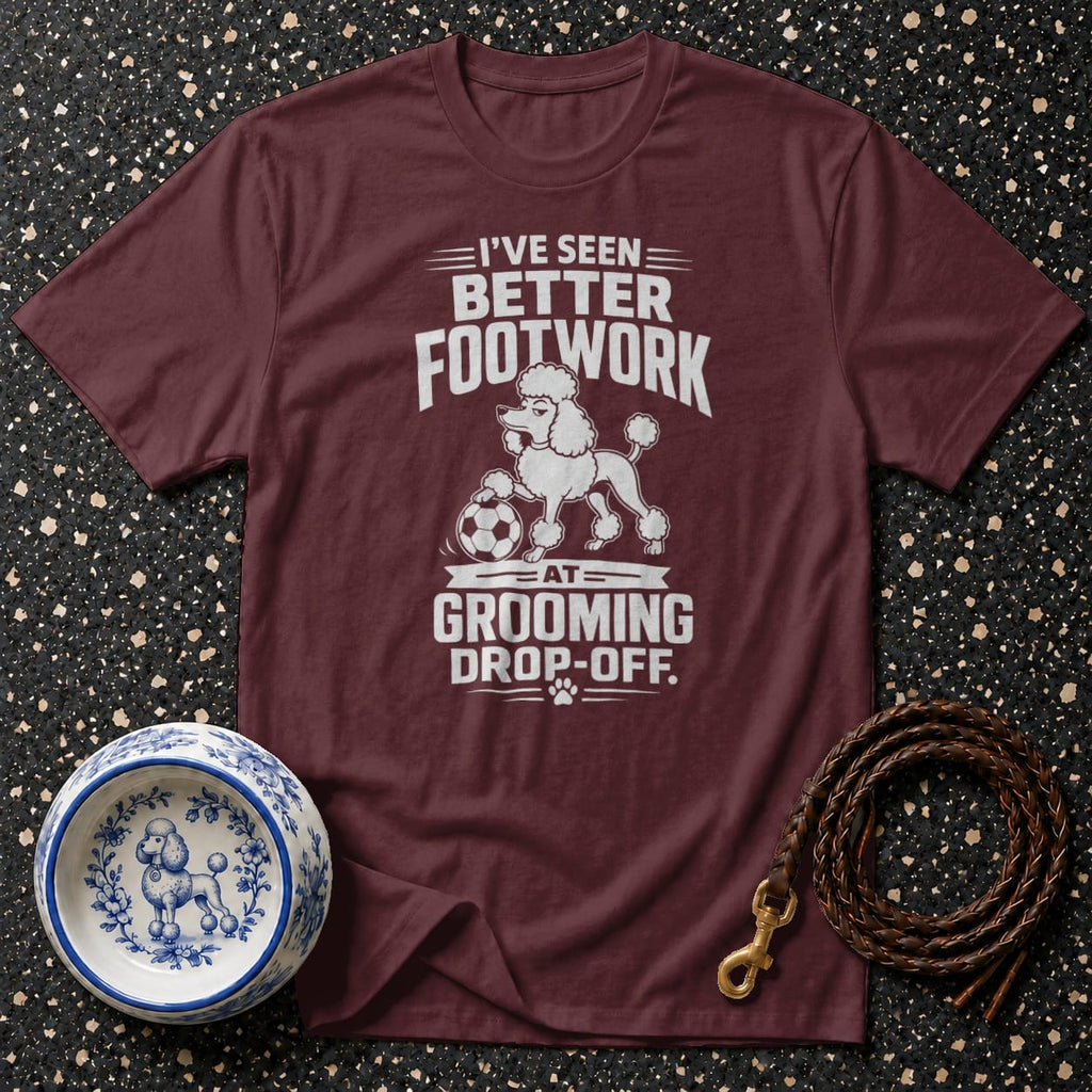 Maroon t-shirt with white text and poodle graphic: "I've seen better footwork at grooming drop-off."