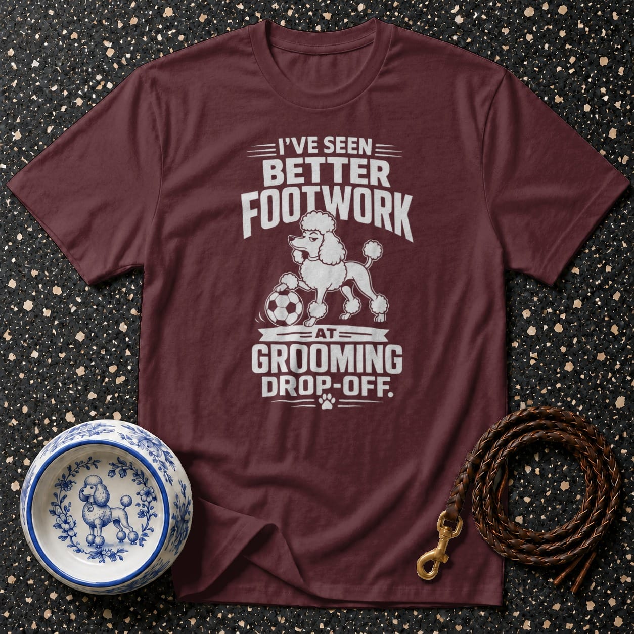 Maroon t-shirt with white text and poodle graphic: "I've seen better footwork at grooming drop-off."