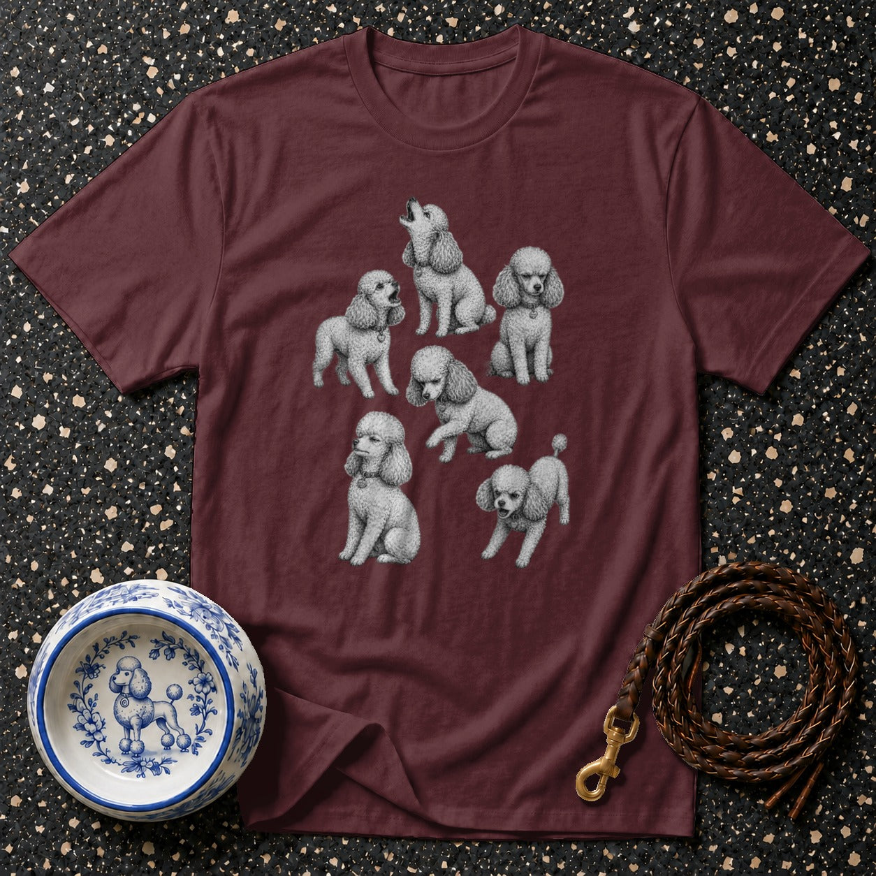 Maroon t-shirt with a print of seven poodles in various poses.