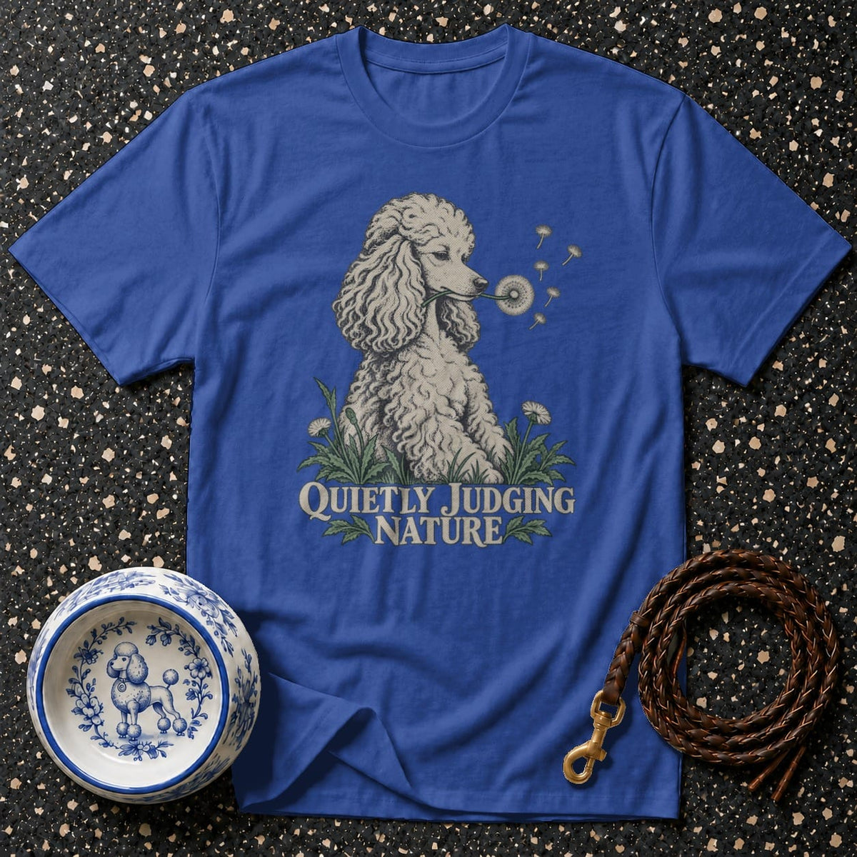 Blue t-shirt with a poodle blowing a dandelion and text "Quietly Judging Nature".