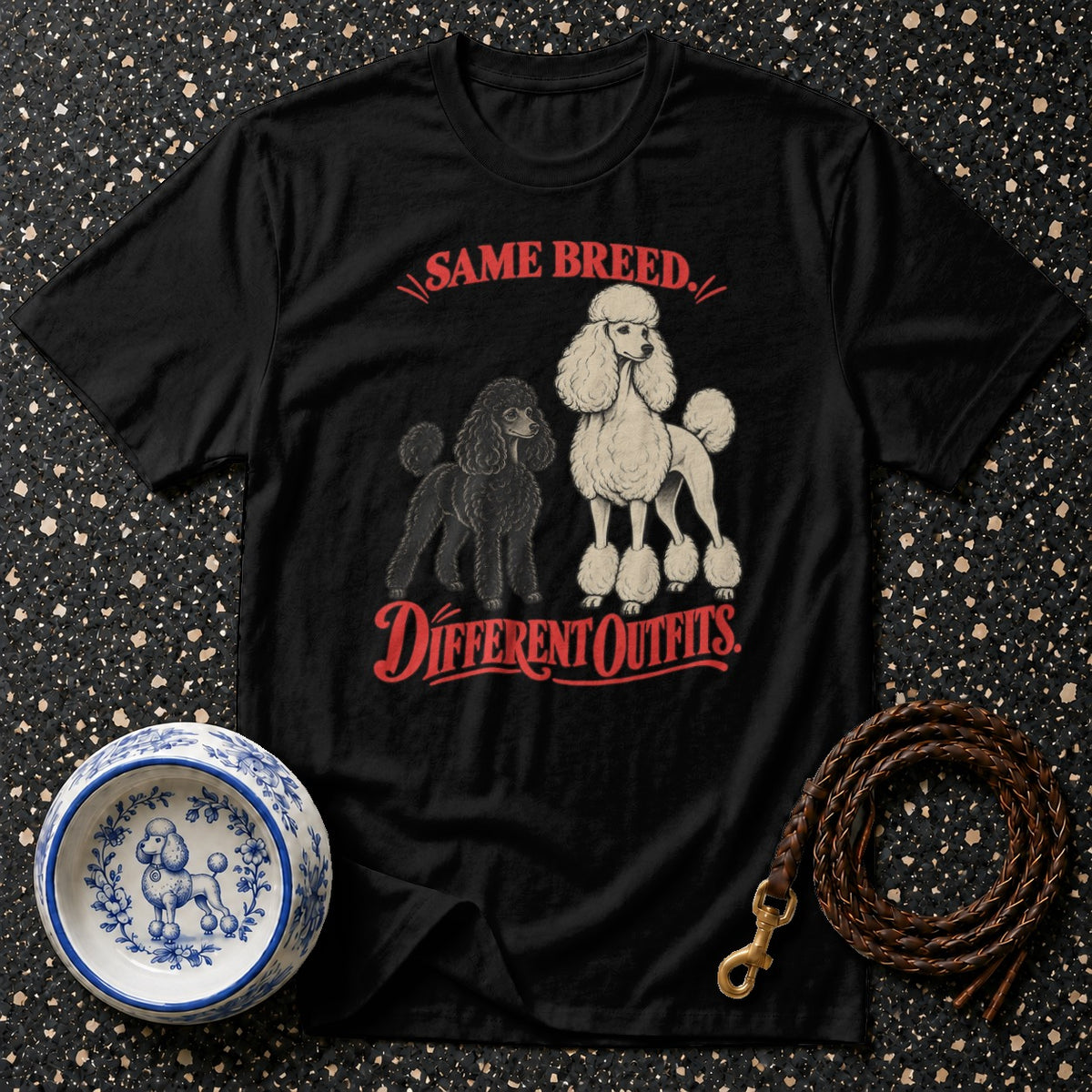 Black t-shirt with red text and graphics of two poodles: "SAME BREED. DIFFERENT OUTFITS."