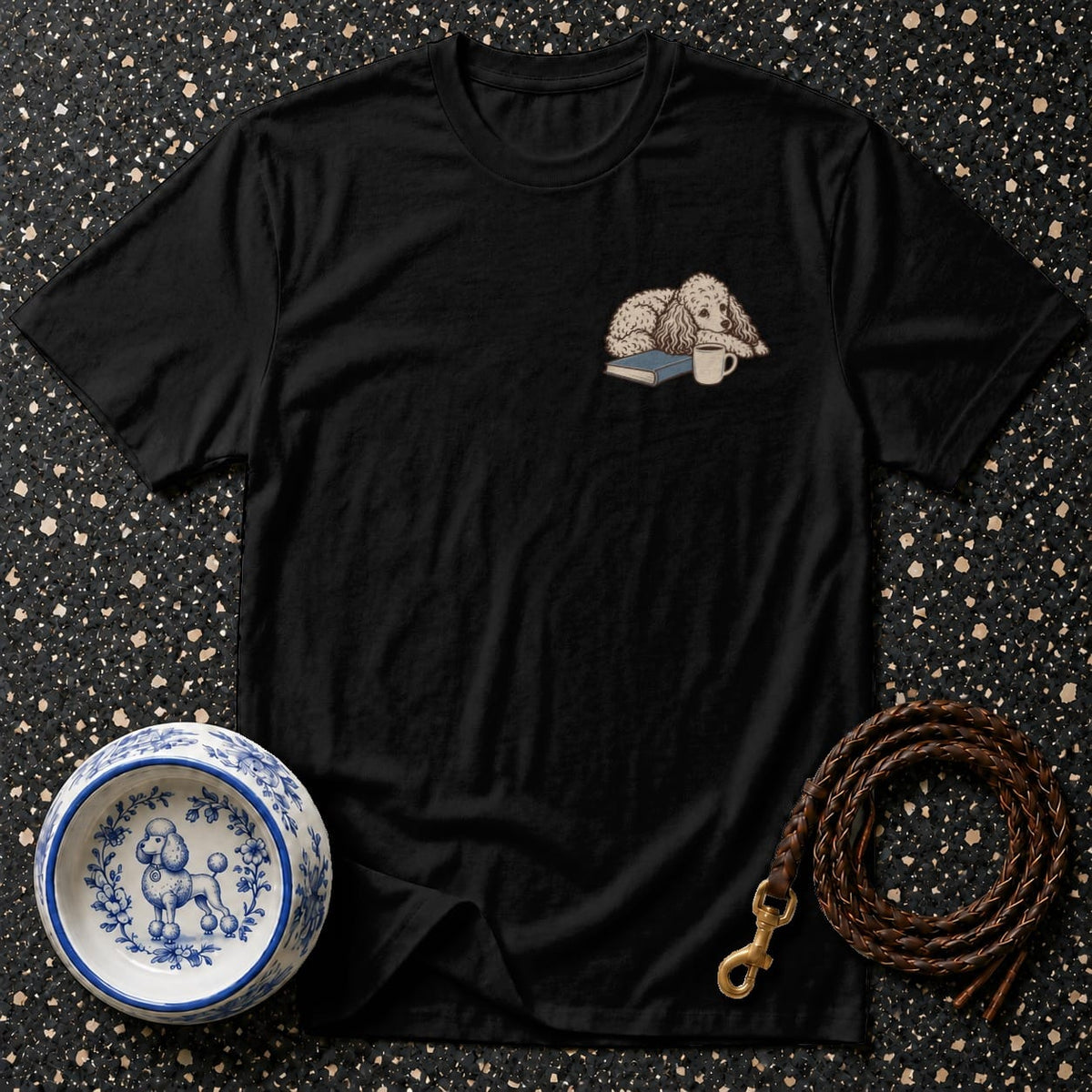 Black t-shirt with embroidered poodle, book, and coffee cup graphic.