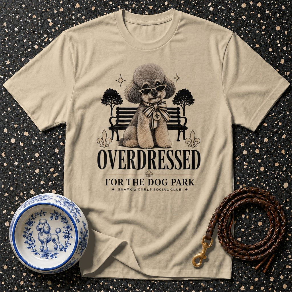 Light tan t-shirt with cartoon poodle wearing sunglasses and text "OVERDRESSED FOR THE DOG PARK."