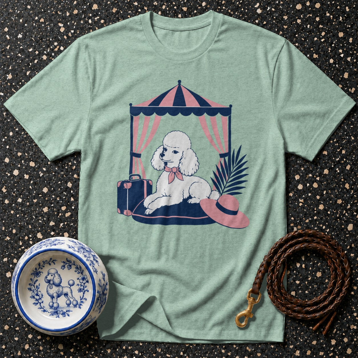 Poodle illustration on a mint green t-shirt under a striped tent.