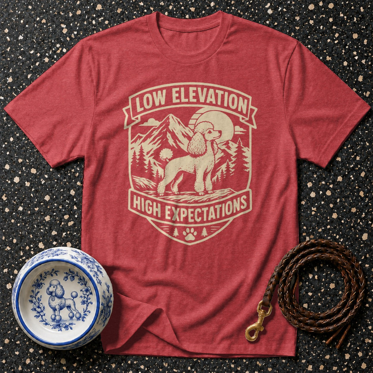 Red t-shirt with graphic of a poodle, mountains, and "Low Elevation High Expectations" text.
