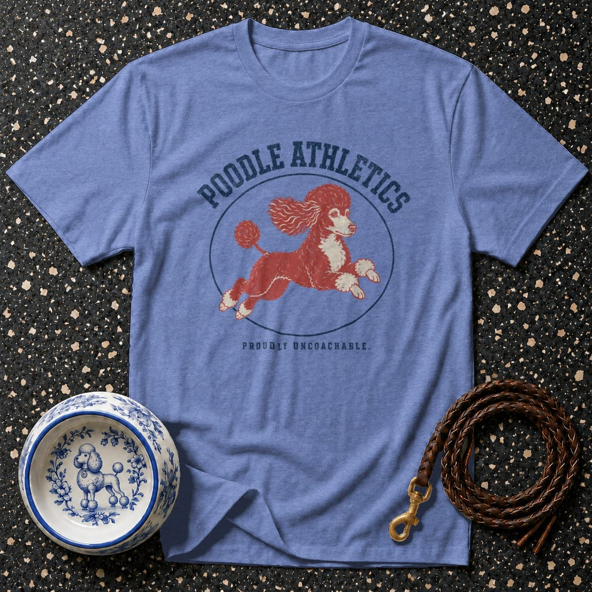 Blue t-shirt with a running red poodle and text "Poodle Athletics" and "Proudly Uncoachable".