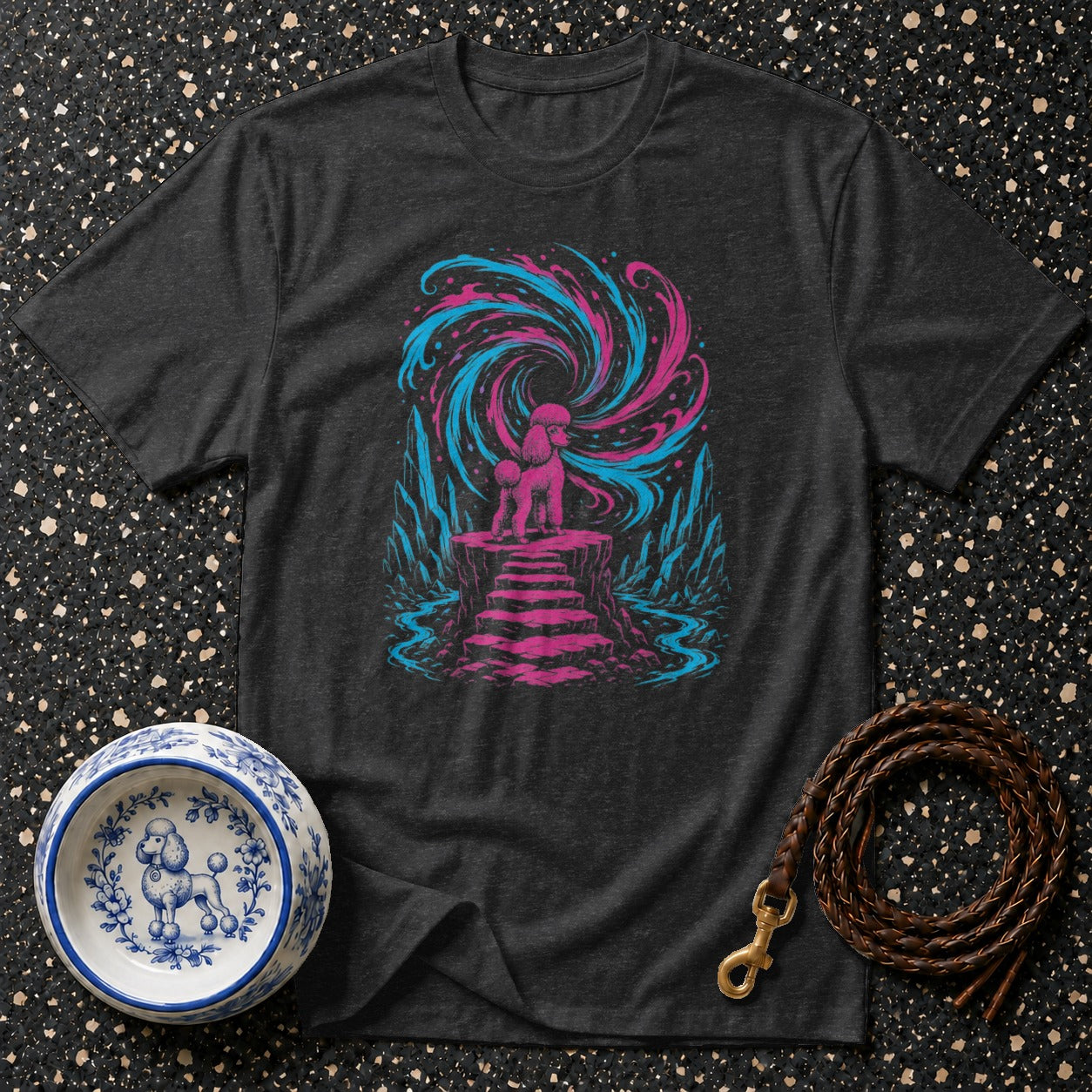 Dark t-shirt with pink and blue poodle graphic on a rock platform.