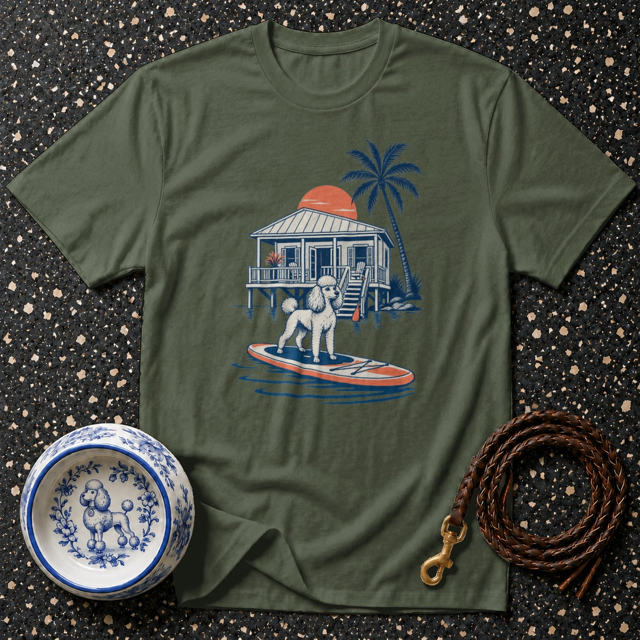 Green t-shirt with illustration of poodle on paddleboard by tropical house.