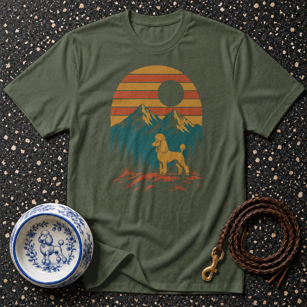 Olive green t-shirt with a vintage sunset mountain graphic featuring a poodle.