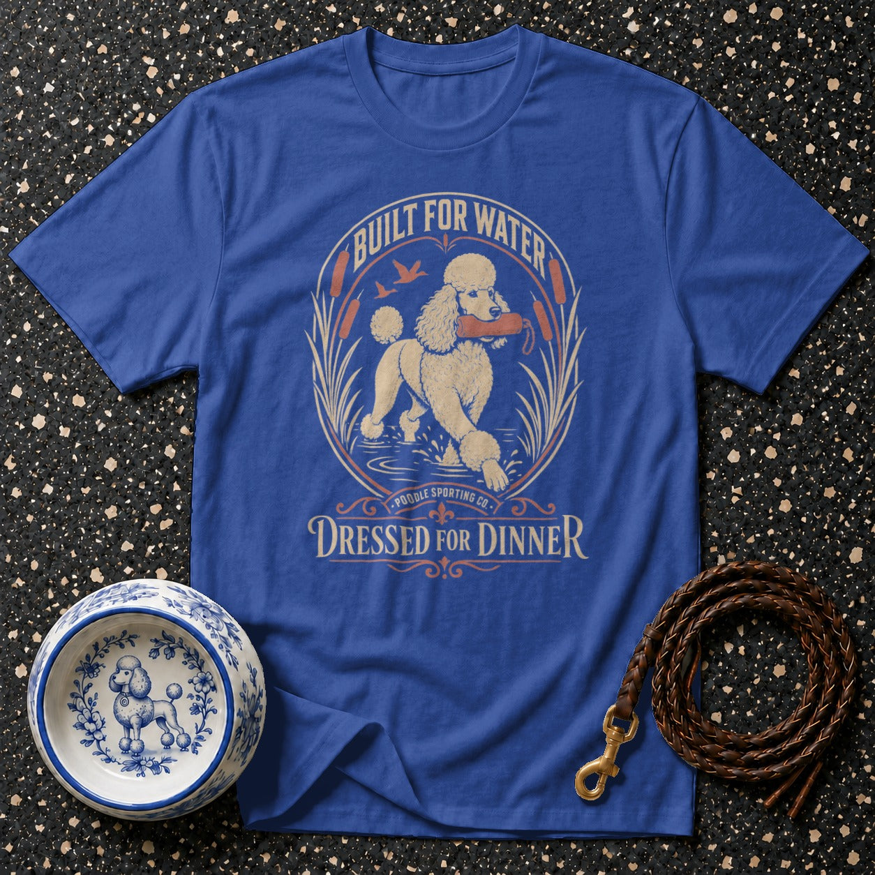 Blue t-shirt with "Built for Water Dressed for Dinner" text and poodle graphic.