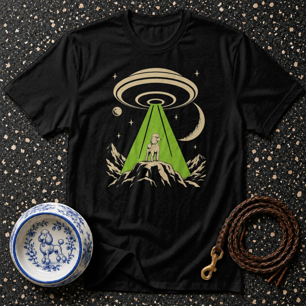 Black t-shirt featuring a poodle on a mountain illuminated by a UFO beam.
