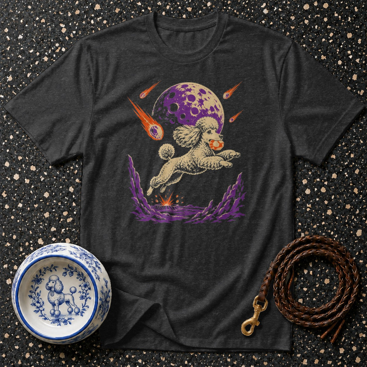 Dark t-shirt featuring a poodle jumping with a ball towards a purple moon and meteors.