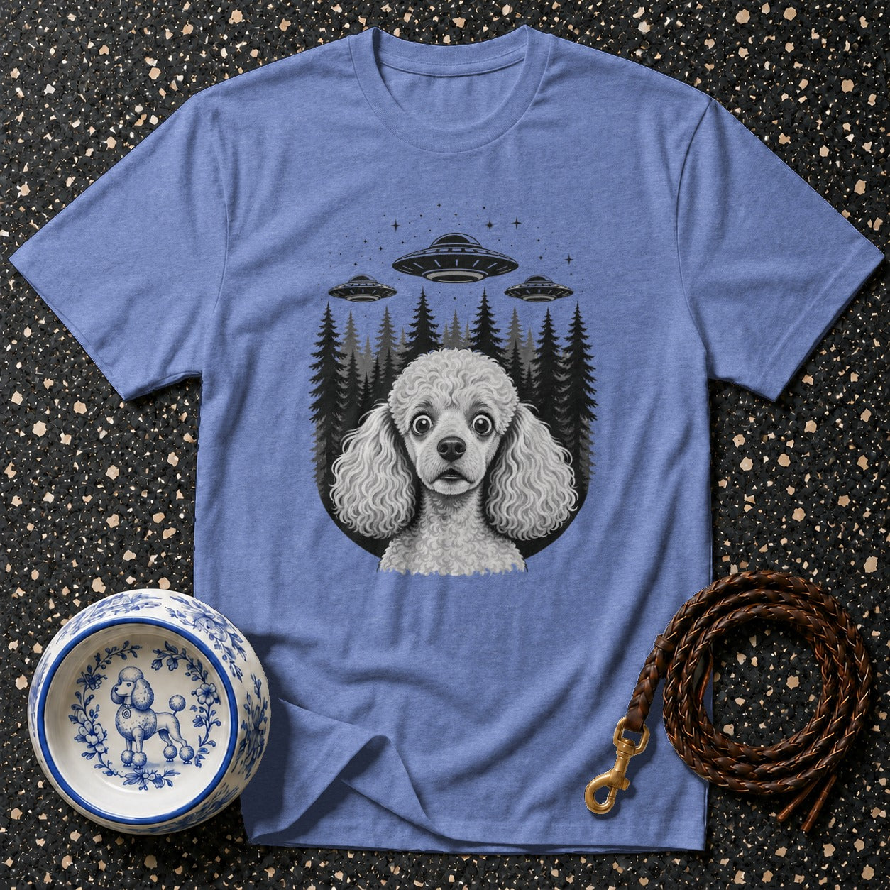 Blue t-shirt with a poodle in front of UFOs and a forest graphic.