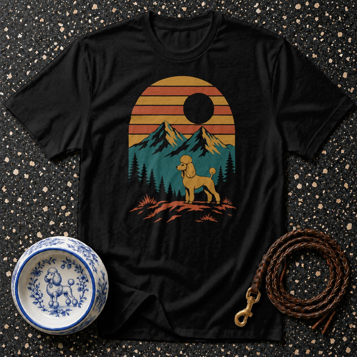 Black t-shirt with a retro sunset graphic featuring a poodle standing in a mountain landscape.