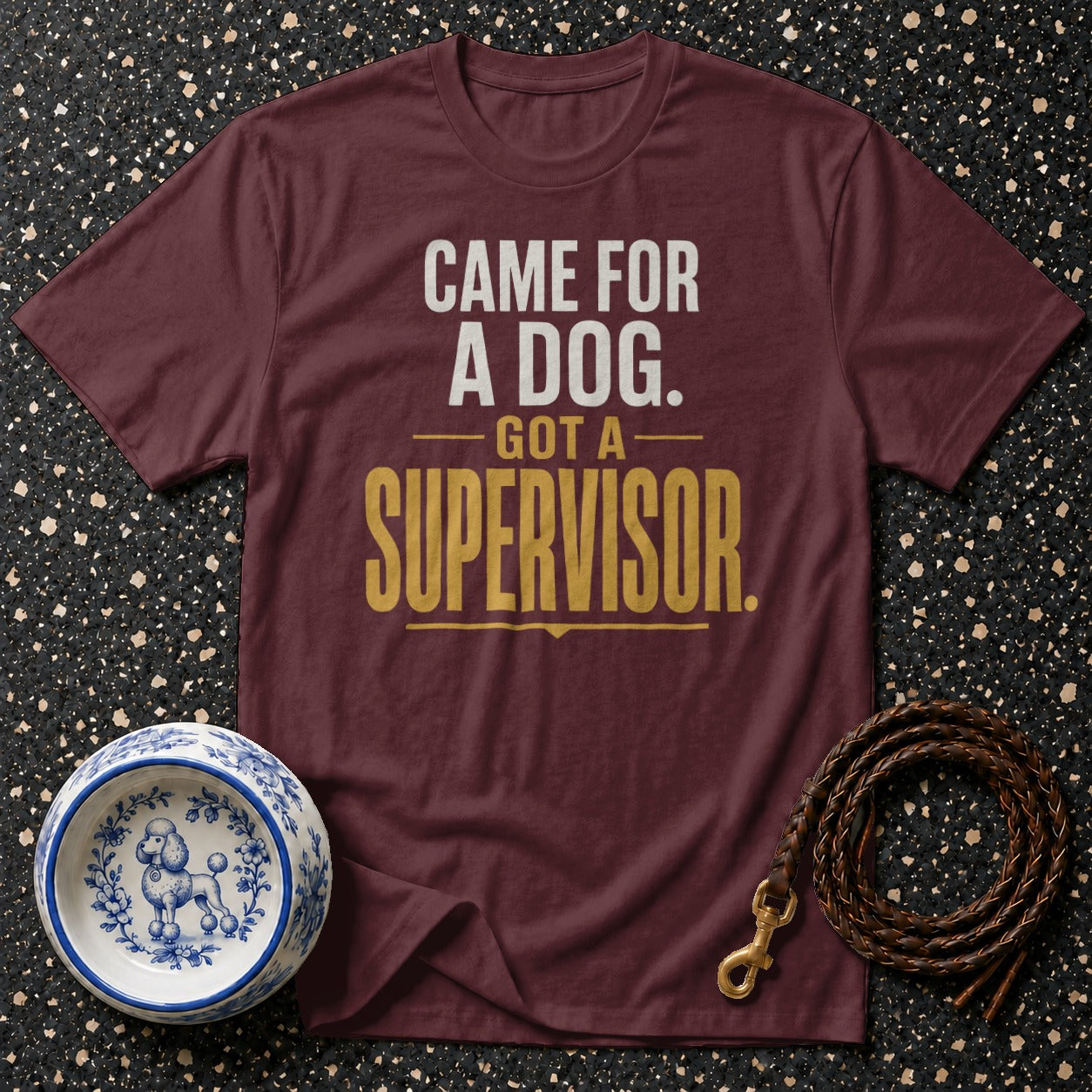 Maroon t-shirt with "CAME FOR A DOG. GOT A SUPERVISOR." text and dog-themed accessories.