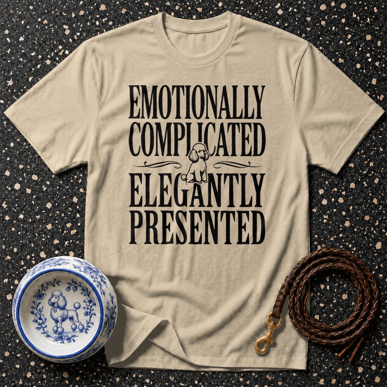 Beige t-shirt with poodle graphic and text: "Emotionally Complicated Elegantly Presented".